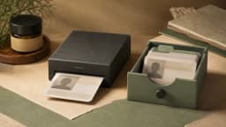 A blank portrait ID enters a countertop scanner beside a separate filing drawer containing similar cards.